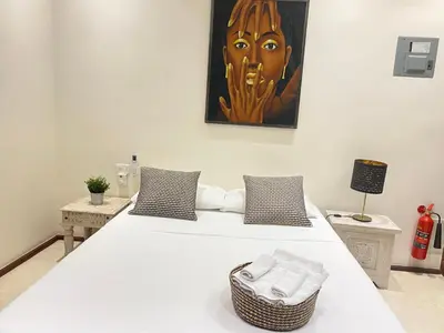 two beds in a room with a painting on the wall at Boutique Hotel Casa Grande, Chocolate Paradise, Estudio superior con Cocina in Santo Domingo