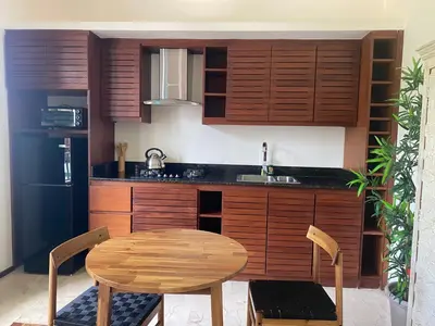 a kitchen with wooden cabinets and a wooden table and chair at Boutique Hotel Casa Grande, Divas Suite in Santo Domingo