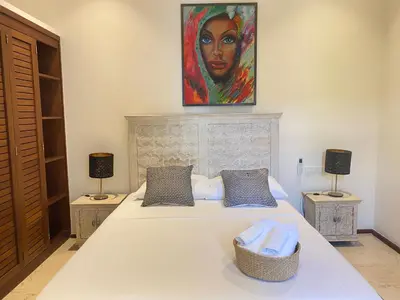 a bedroom with a bed with a painting on the wall at Boutique Hotel Casa Grande, Divas Suite in Santo Domingo