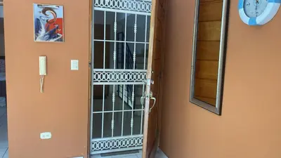 a door to a room with a mirror and a clock at Edificio maremma 6 in Boca Chica