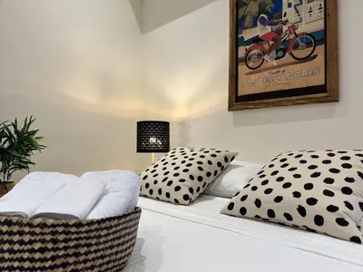 a white bed with polka dots and pillows on it at Boutique Hotel Casa Grande, Dominican Voyage, Suite familiar de 2 dormitorios in Santo Domingo
