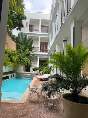 a courtyard with a pool and chairs and a building at Boutique Hotel Casa Grande, Dominican Voyage, Suite familiar de 2 dormitorios in Santo Domingo