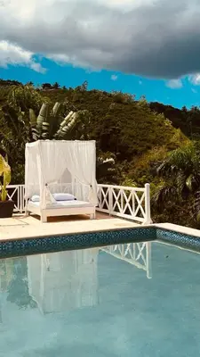 a pool with a bed and a chair next to at Villa Blanca, Las Terrenas, 4 chambres in Las Terrenas