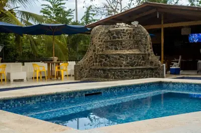 a swimming pool with a stone wall next to a table at Spectacular Country Villa in Pedro Brand