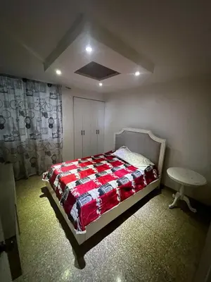 a bedroom with a bed and a table in it at Comfortable apartment in Santo Domingo