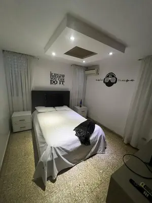 a bedroom with a large bed with white sheets at Comfortable apartment in Santo Domingo