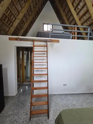 a ladder leading up to a bunk bed in a room at Charming Bungalow with Pool in Sosúa