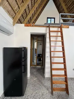 a black refrigerator and a ladder in a room at Charming Bungalow with Pool in Sosúa