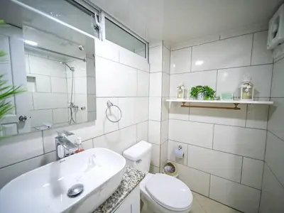 a white bathroom with a sink and a toilet at Central 1BR APT - 1 minute Walking from Rumba in Sosúa