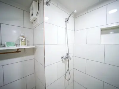 a bathroom with a shower with white tiles at Central 1BR APT - 1 minute Walking from Rumba in Sosúa