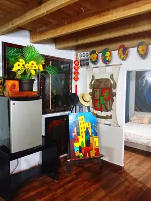 a living room with a bed and a tv at Chalet Thevenin Art Accommodation in Jarabacoa