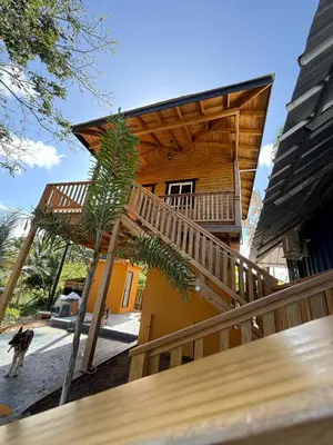 a house with a wooden staircase leading up to a building at Villas Gabriel in Nagua