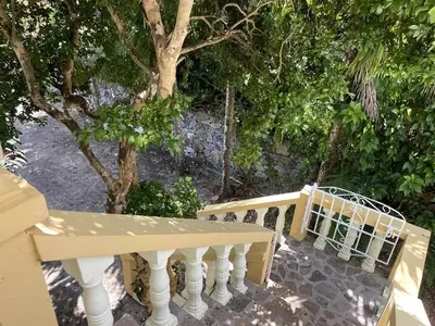 a porch with a white railing and a tree at Chalet Larimar Charming villa in Las Galeras in Las Galeras