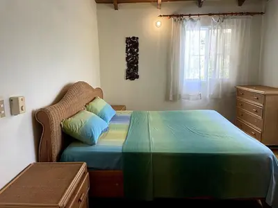 a bedroom with a bed and a dresser and a window at Chalet Larimar Charming villa in Las Galeras in Las Galeras