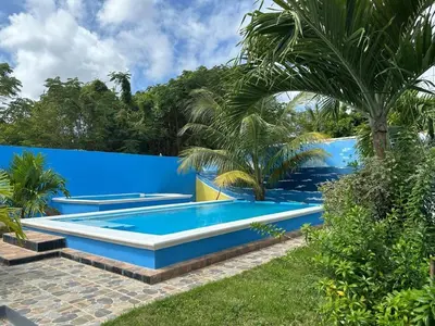 a swimming pool in a backyard with a blue fence at Apartamento Costero 2 en Las Galeras in Las Galeras