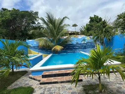 a swimming pool in a resort with palm trees at Apartamento Costero 3 en Las Galeras de Samaná in Las Galeras