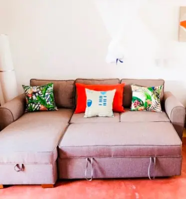 a couch with pillows on it in a living room at Lovely Beach Apartment in Tranquil Playa Bonita in Las Terrenas