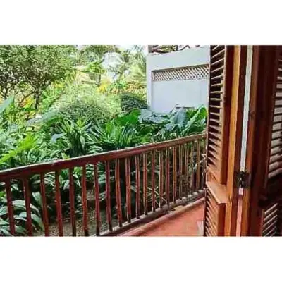 a balcony with a wooden railing and plants at Lovely Beach Apartment in Tranquil Playa Bonita in Las Terrenas