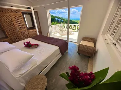 a bedroom with a bed with a view of a balcony at Villa blanca chambre d'hôtes vue sur mer in Las Terrenas
