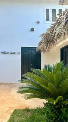 a black door of a white building with a plant at Villa blanca chambre d'hôtes vue sur mer in Las Terrenas