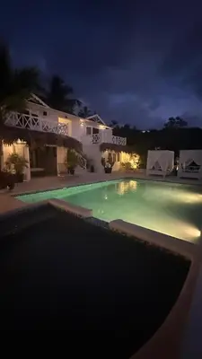 a swimming pool in front of a house at night at Villa blanca chambre d'hôtes vue sur mer in Las Terrenas