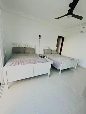 two beds in a white room with a ceiling fan at Eden Caribe Condo, Bavaro Punta Cana in Punta Cana