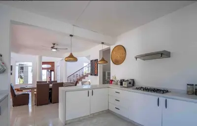 a kitchen with white cabinets and a dining room at Villa with Oceanviews for All Types of Travelers in San Felipe de Puerto Plata