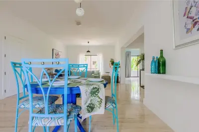a dining room with a blue table and chairs at Suite tropical in Punta Cana