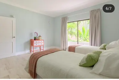 two beds in a bedroom with a window at Suite tropical in Punta Cana