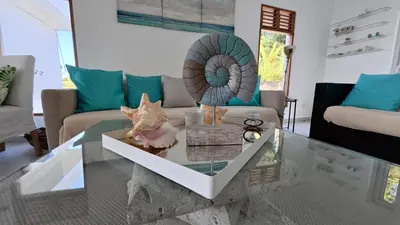 a living room with a glass table and a couch at The Nest, a quiet refuge with impressive views in Las Terrenas