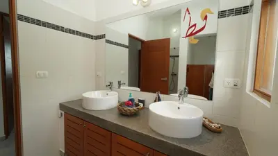 a bathroom with two sinks and a large mirror at The Nest, a quiet refuge with impressive views in Las Terrenas