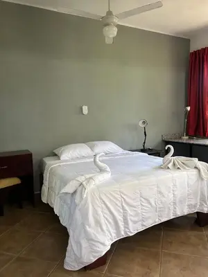 a bedroom with a large bed with white sheets at CASA Angelo in Sosúa