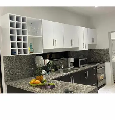 a kitchen with white cabinets and a bowl of fruit on a counter at Villakeyden1 in Colorado