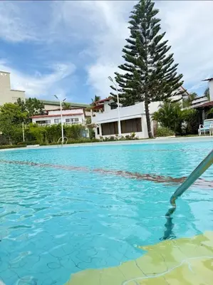 a swimming pool with blue water at Villa Luddy Beach & Relax in Juan Dolio
