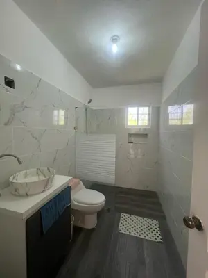 a white bathroom with a toilet and a sink at apartment for rent in Bayahibe