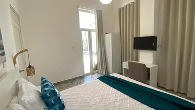 a room with a bed with a blue blanket on it at Hotel Boutique Brisas Colonial in Santo Domingo