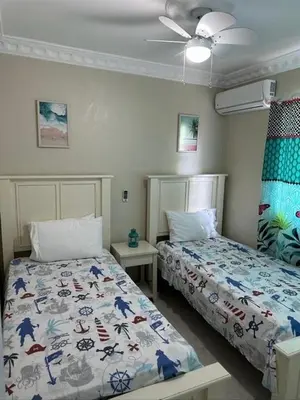 a bedroom with two beds and a ceiling fan at Lunamare Residence in Los Grini