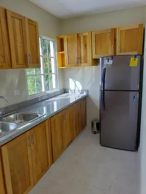 a kitchen with a stainless steel refrigerator and wooden cabinets at Lunamare Residence in Los Grini