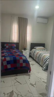 a bedroom with two beds and a tiled floor at Los laureles in Puerto Plata