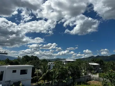 a blue sky with clouds and trees and buildings at Hermoso Apartamento en 3er nivel con terraza privada in Bonao