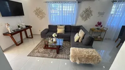 a living room with a couch and a table at Villa Tropical Paradise Pool Rooftop in San Felipe de Puerto Plata