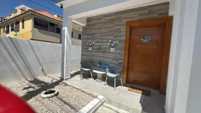 a house with a wooden door and two chairs at Villa Tropical Paradise Pool Rooftop in San Felipe de Puerto Plata