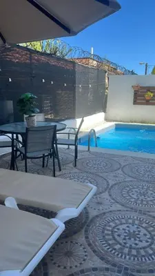 a patio with a table and chairs and a pool at Villa Tropical Paradise Pool Rooftop in San Felipe de Puerto Plata