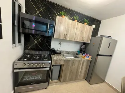 a small kitchen with a stove and a refrigerator at Sweet dreams Tropical paradise in San Isidro