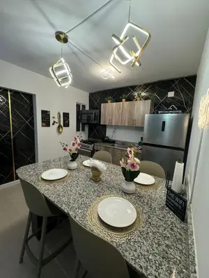 a kitchen with a table with chairs and a counter top at Sweet dreams Tropical paradise in San Isidro