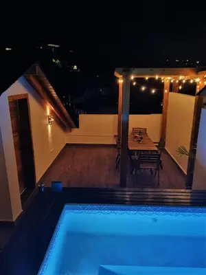 a house with a swimming pool at night at Apartment w private terrace and Jacuzzi in Las Terrenas