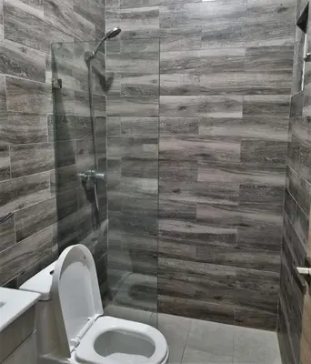 a bathroom with a toilet and a glass shower at Apartment w private terrace and Jacuzzi in Las Terrenas