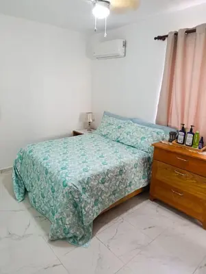 a bedroom with a bed and a wooden dresser at Acogedor apartamento a cerca de la playa in San Felipe de Puerto Plata