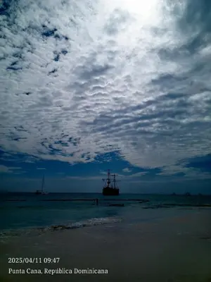 a ship in the ocean under a cloudy sky at Cerca de la playa apartamento familiar in Punta Cana