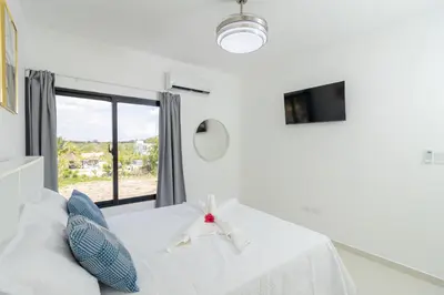 a white room with a bed and a window at Cozy 2BR Apartment in Sunshine Bayahibe in San Rafael del Yuma